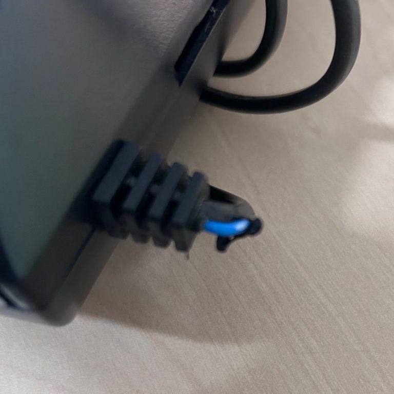 cable found on PAT test Close-up of a black power cable connector with a blue wire.