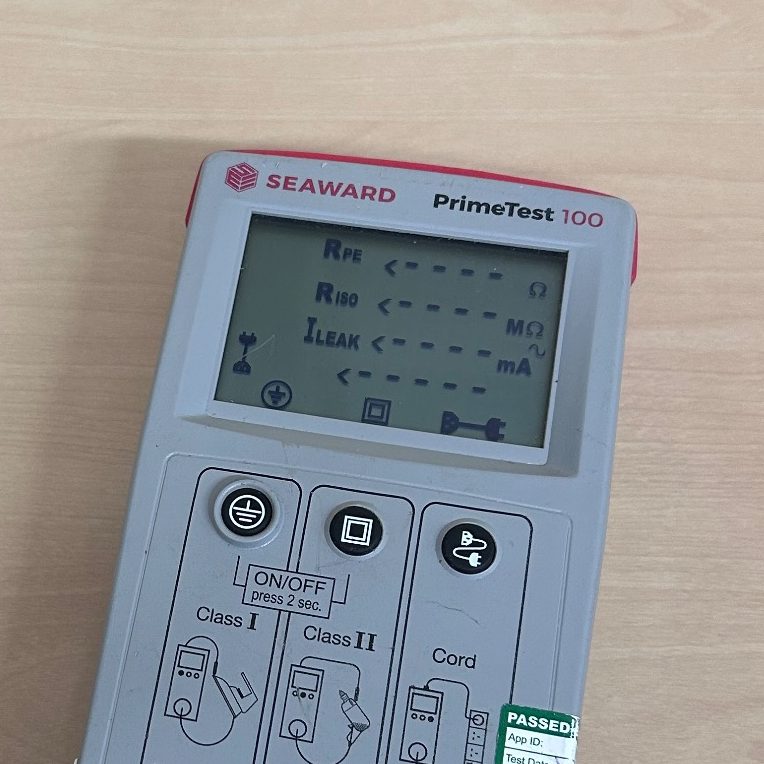 SEward pat test machine, A grey digital device with a screen displaying various test results and settings.